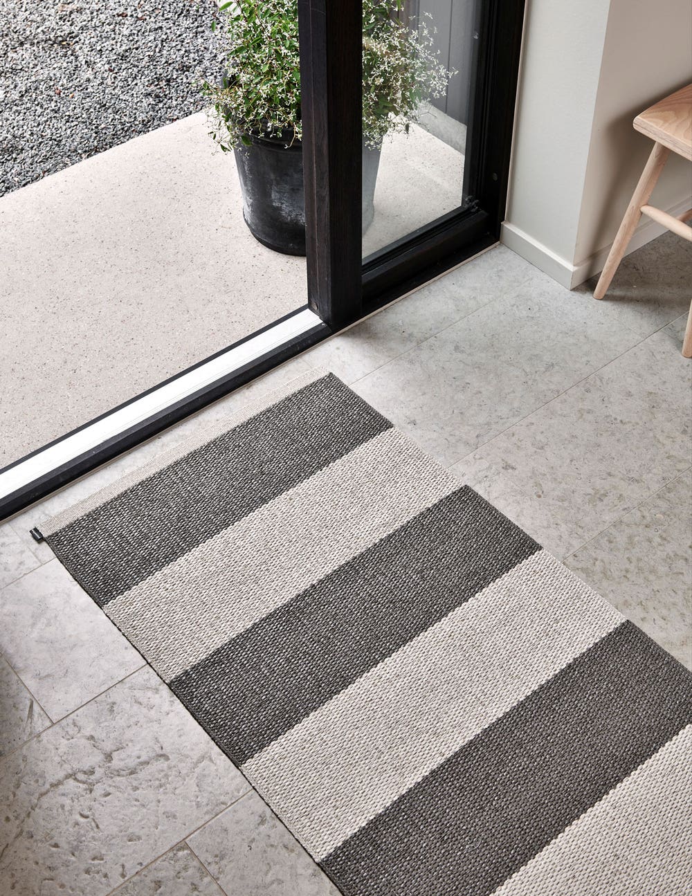 Pappelina-Bob-Gangmatta-Linen-Charcoal-Miljo_1.jpg Bob Gångmatta i färgen Charcoal / Linen framför öppen dörr