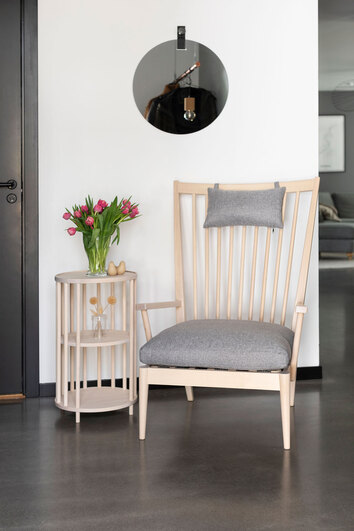 Orust Sidobord i vitpigmenterad björk med en bukett tulpaner bredvid en pinnfåtölj