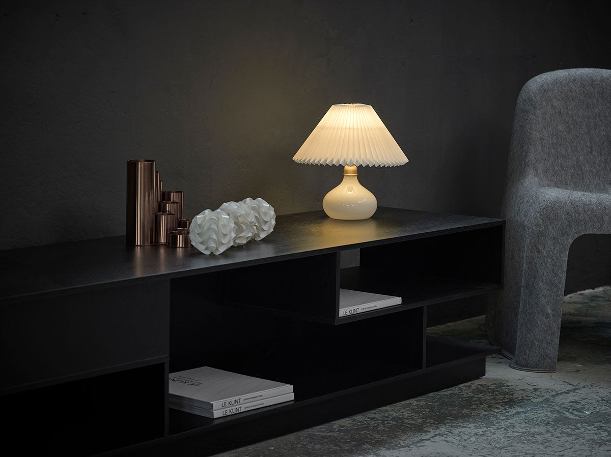 En tänd Le Klint 314 Bordslampa på skänk i vardagsrum