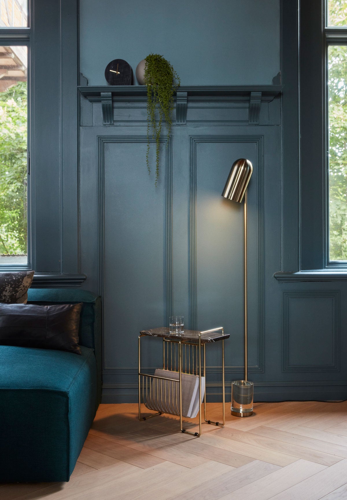 Sino Tidningsställ Brun Marmor/Guld bredvid en guldig golvlampa i vardagsrumsmiljö