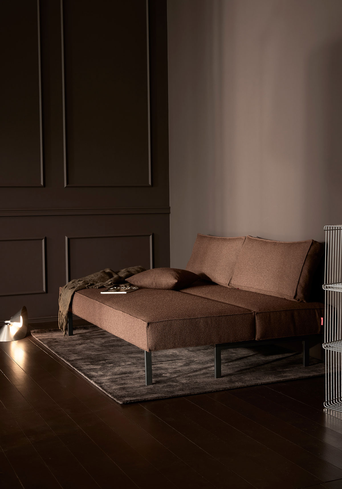 Sly Bäddsoffa i tyget 359 Taura Cappuccinoi utfällt läge i mörkt vardagsrum