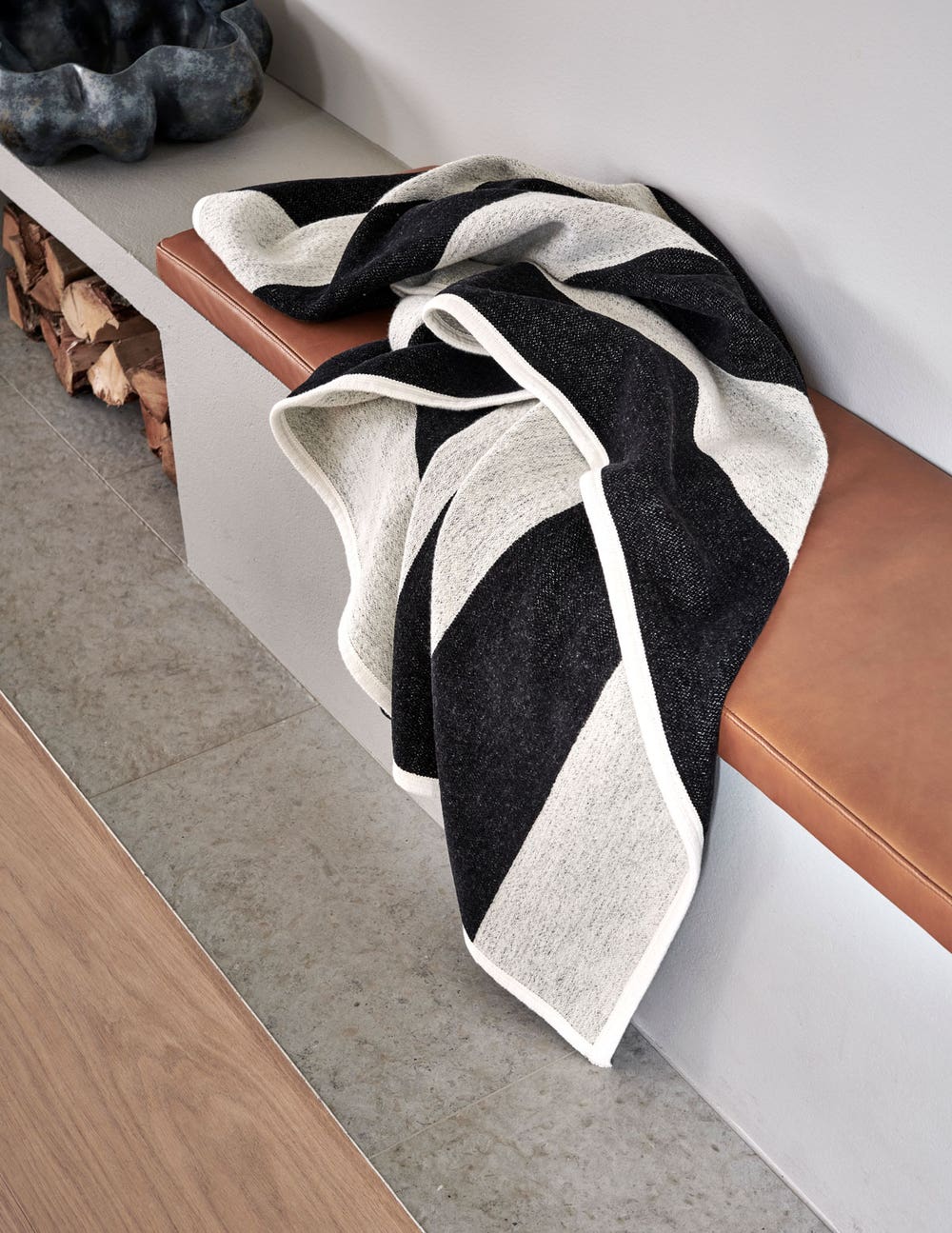 Pappelina-Bob-Filt-Black-Miljo.jpg Bob Pläd i färgen Black / Vanilla på en sittbänk