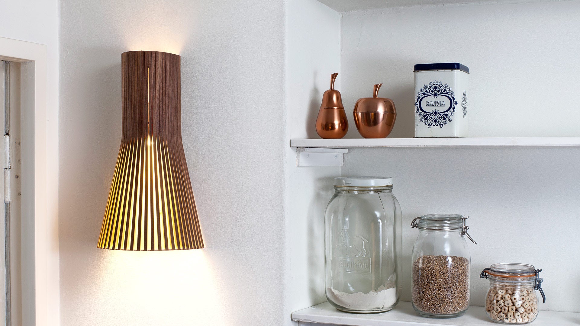 Secto small 4231 Vägglampa Valnöt på vägg i kök bredvid ett öppet skafferi
