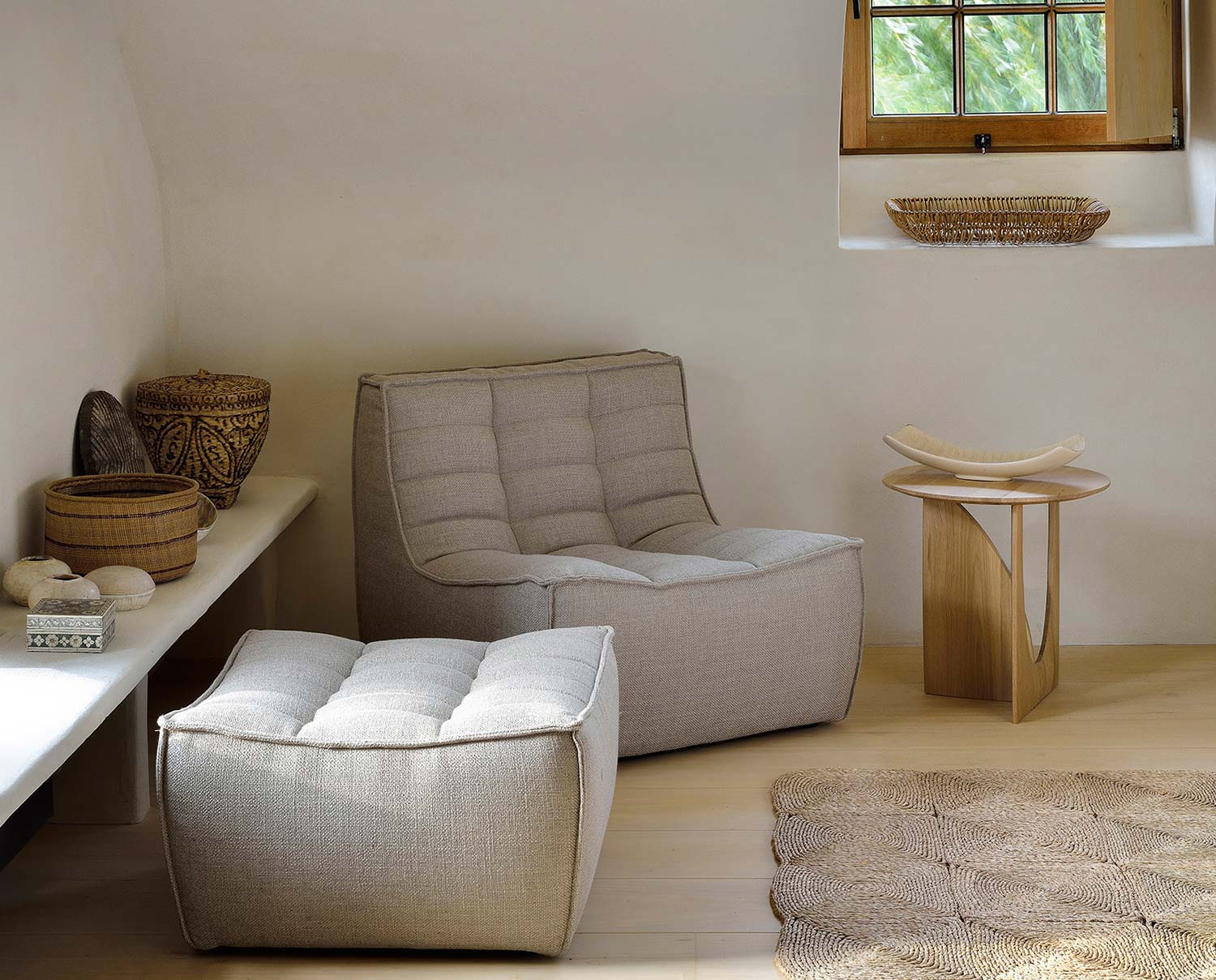 N701 Fåtölj och fotpall i beige tyg i naturlig miljö