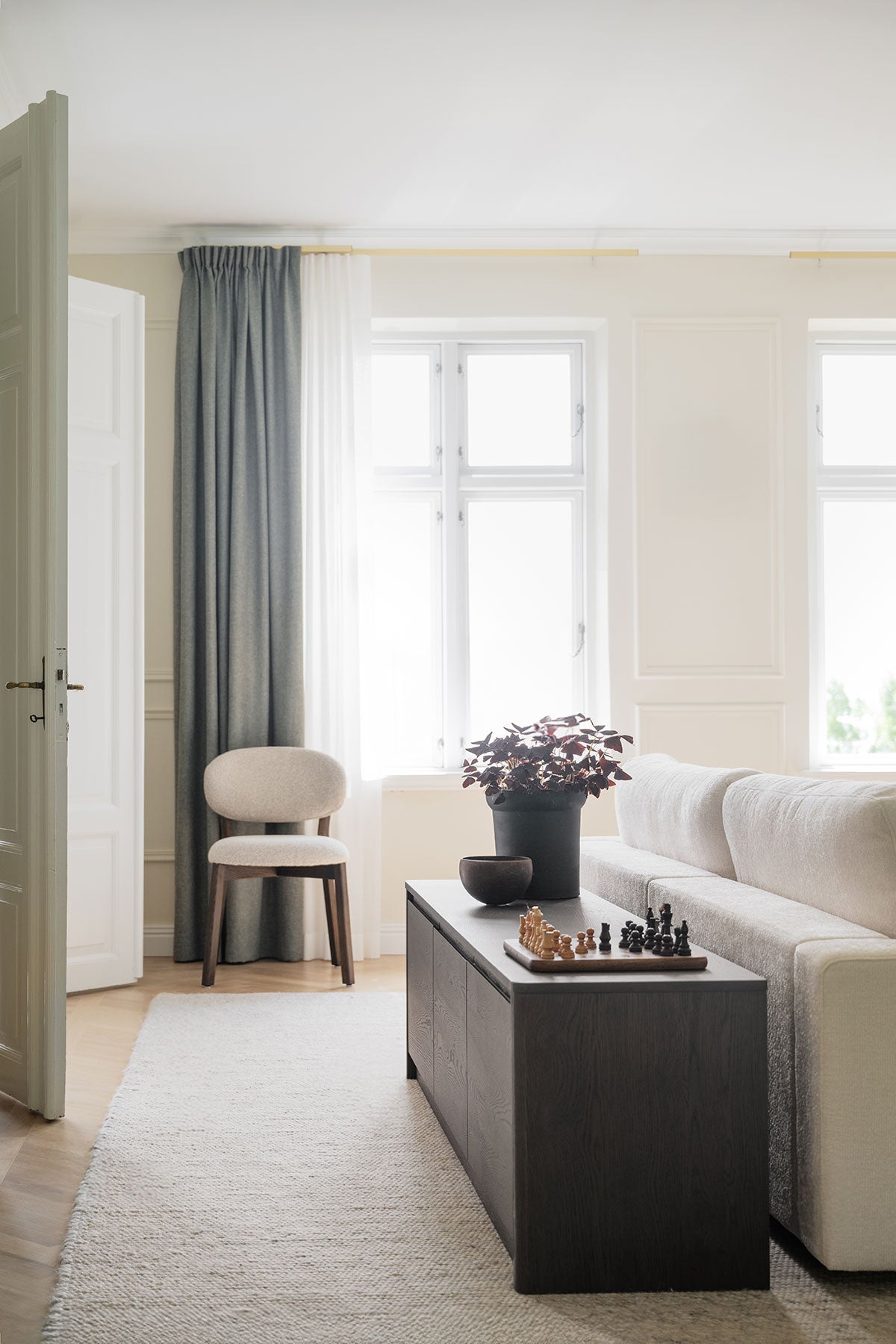 Melstone Sideboard i höjd 50 centimeter i brun ek bakom en beige soffa