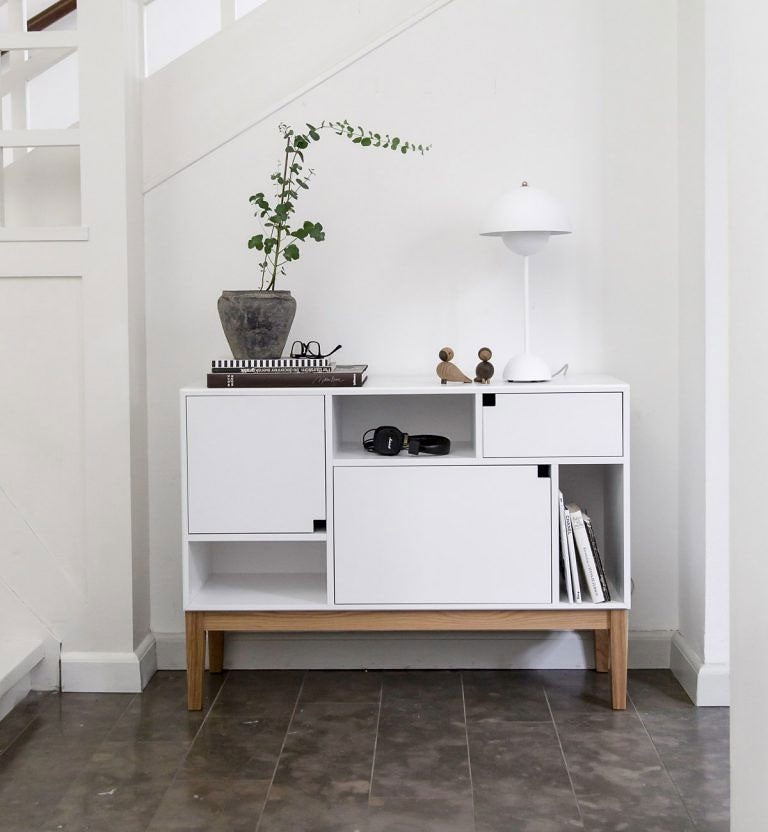 Citti Skåp i färgen Angel White. Skåpet står i hall och är dekorerat med blomma, lampa och inredningsattiraljer.