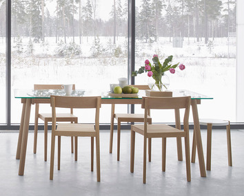 Corners Bord i vitoljad ek med matstolar framför fönster som vetter ut mot ett vinterlandskap