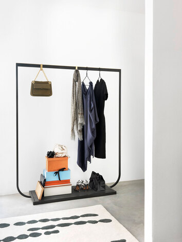 Tati Klädhängare i bredd 130 centimeter i färgen Char Grey med stenskiva i Neo Marquina med kläder, väskor och skor