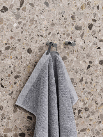 Vipp Handduk i badrumsmiljö med mönstrat terrazzokakel