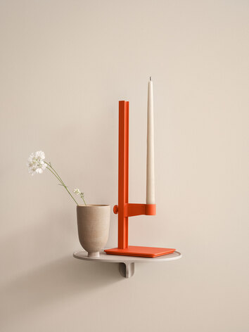 String Museum Ljusstake Orange på beige vägghylla med vas