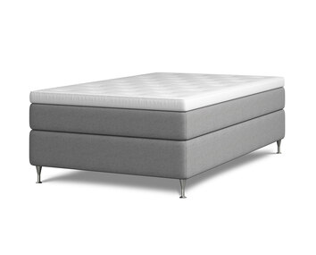 Kontinentalsängen Harmoni.  Bilden visar Harmoni med en bredd av 120 centimeter. Sängen är klädd i ljusgrått tyg. Benen är av förkromat stål. 