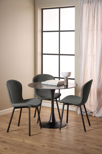 Tre stycken Esra Stol i tyget Apia Mörkgrå som står omkring ett runt matbord