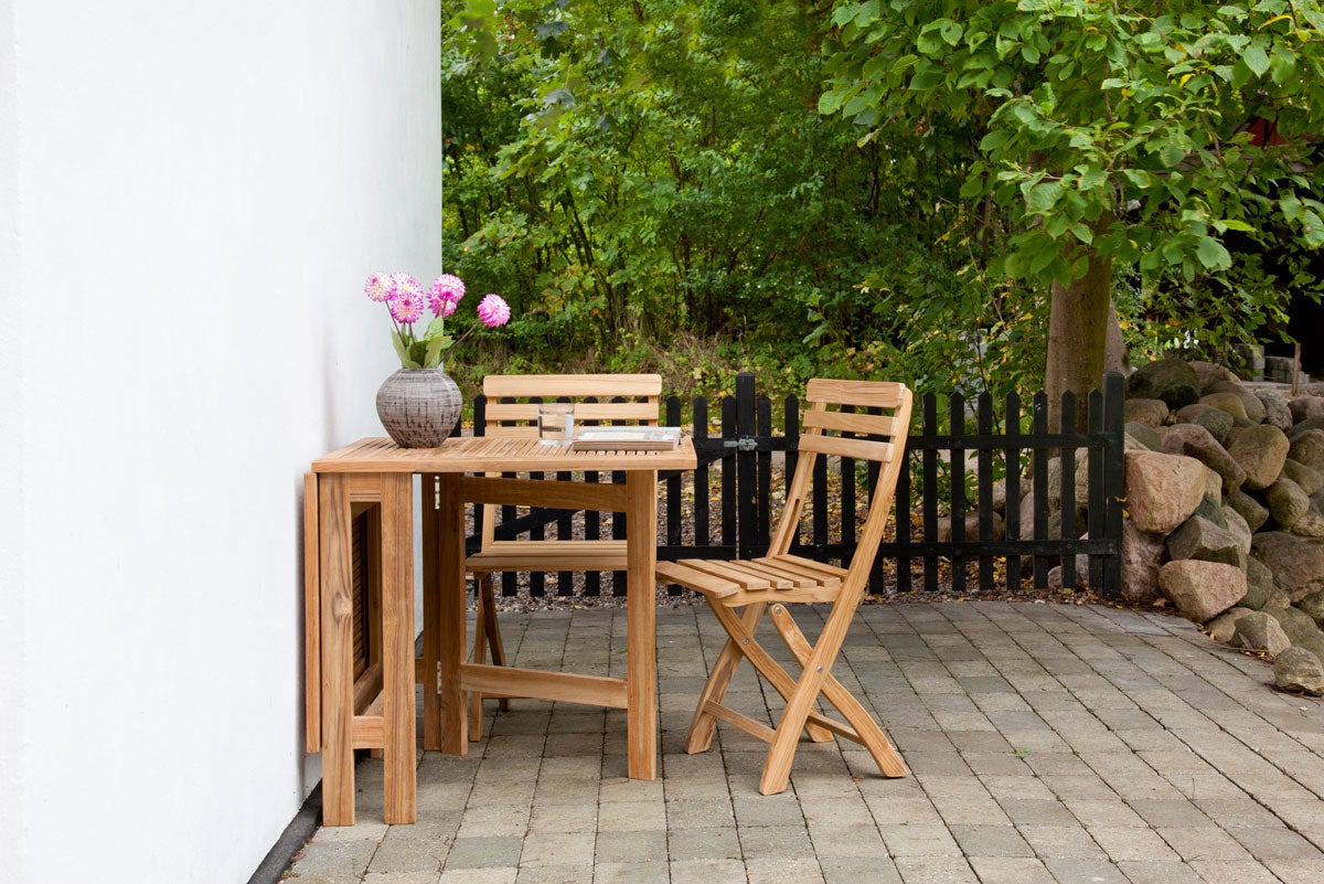 Clarish Klappstol Teak vid klaffbord i utomhusmiljö