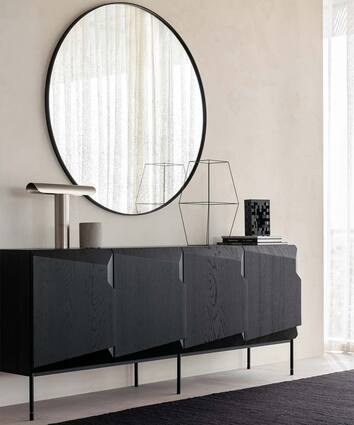 Stairs Sideboard i svart ek dekorerad med en bordslampa, doftljus, böcker och en skulptur