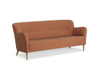 Soffan Nova i tresitsig modell. Soffan är klädd i tyget Patina 09, med ben i oljad ek. 