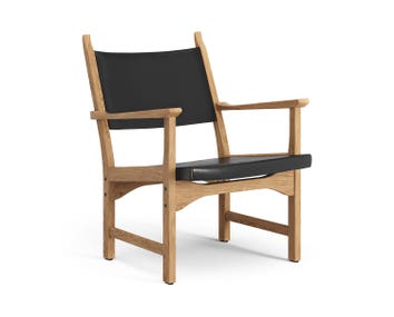 Fåtöljen Caryngo. Här visade i oljad ek, med sits i svart sadelläder.