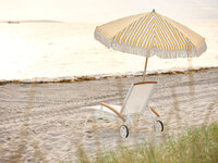 Gatsby Parasoll Gul / Vit på stranden bredvid en vit solstol