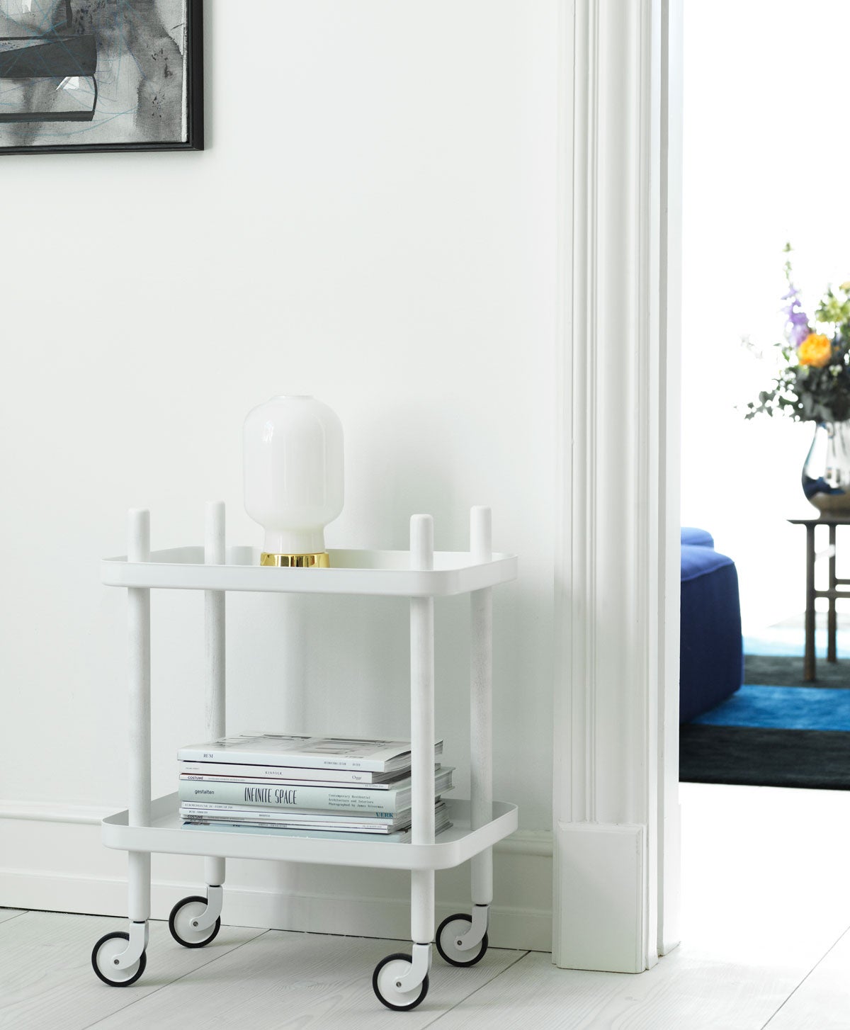 Block Bord Vit med vit bordslampa och tidningar staplade på hög