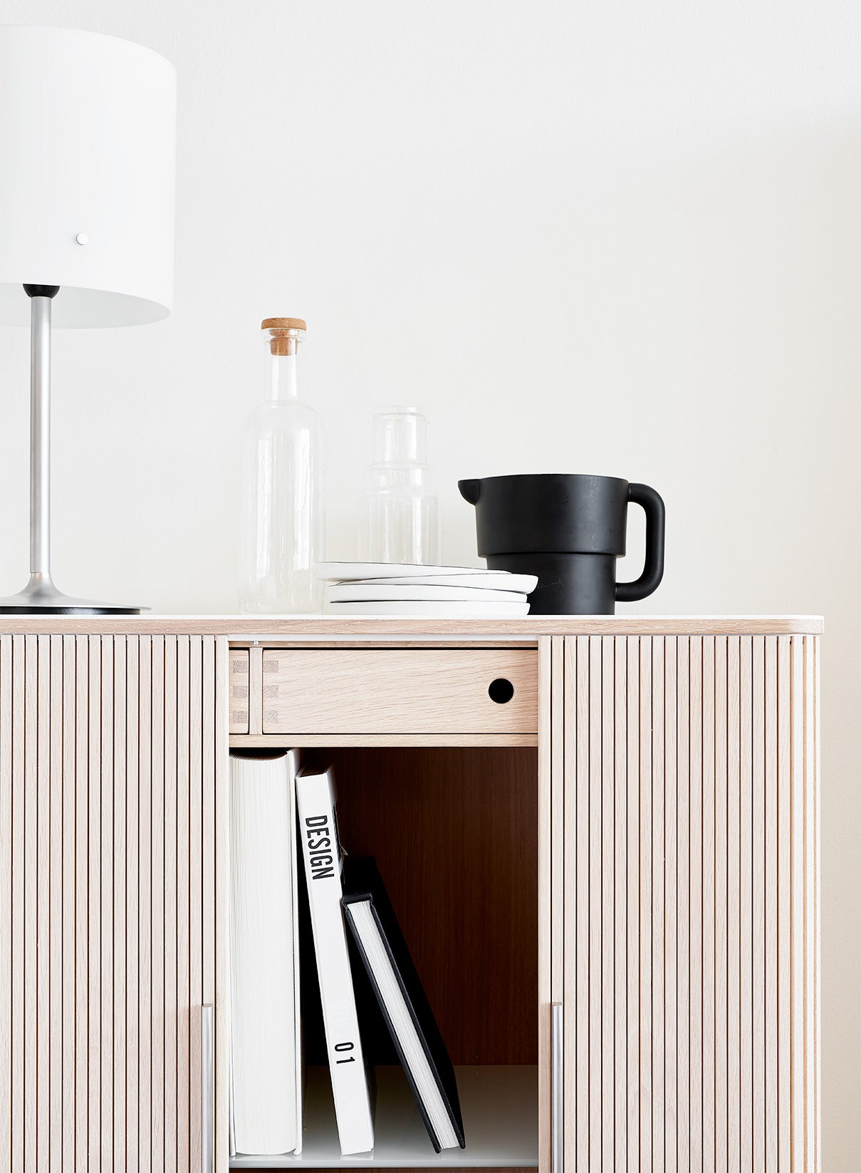 AK 2740 Skåp med öppna luckor. Skåpet är dekorerat med en karaff, en kanna och tallrikar i porslin.