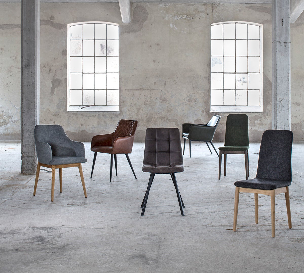 Torkelson stolar i olika modeller i en cool, gammal fabrikslokal med höga spröjsade fönster.
