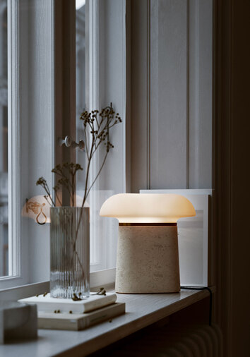 Nova Bordslampa Travertin i fönsterkarm med en räfflad vas med blommor