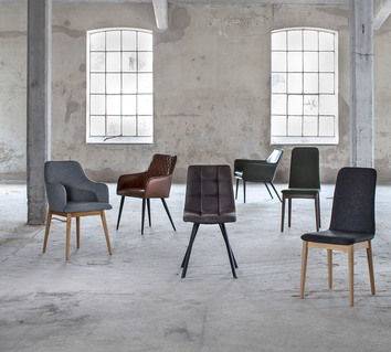 Torkelson stolar i olika modeller i en cool, gammal fabrikslokal med höga spröjsade fönster.