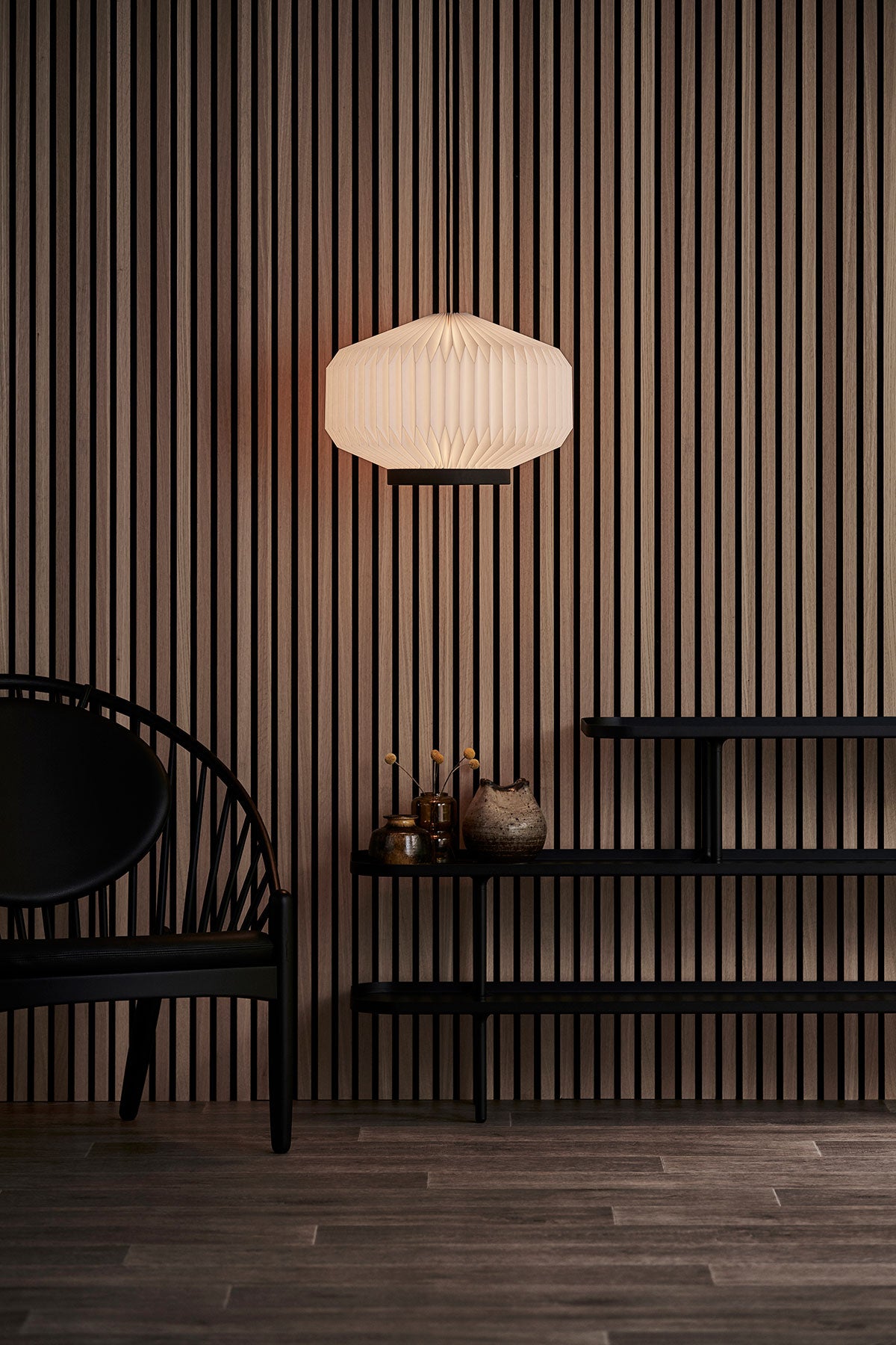 En tänd Shibui Pendel 186 hängande ovanför fristående hylla