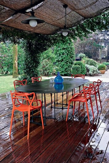 Masters stolar i orange på regnig en uteplats.