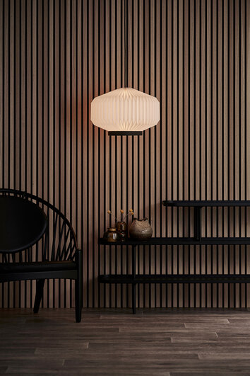 En tänd Shibui Pendel 186 hängande ovanför fristående hylla