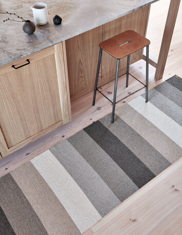 Molly Gångmatta Clay på köksgolv intill köksbänk med barpall
