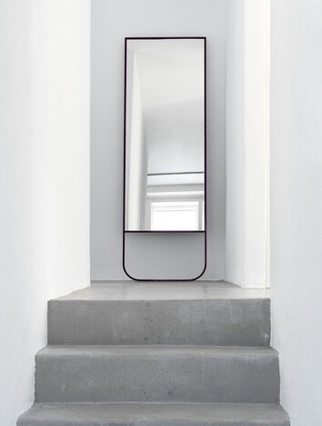 Tati Spegel i färgen Char Grey på toppen av en trappa