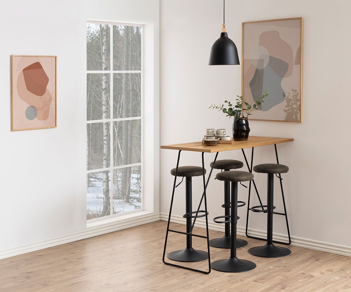 Fyra stycken Finch Barpall i tyget Preston Antracit som står runt ett rektangulärt barbord i trä. Barbordet är dekorerat med porslin och en vas.