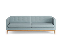 Bilden visar Madison, i tresitsig modell. Soffan är klädd i tyget Retro 18, med knappar i ryggen. Benen är i oljad ek. 