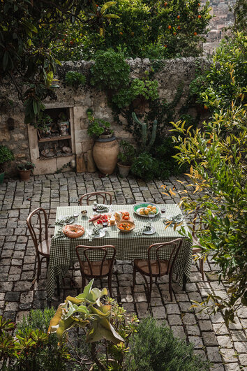 Misty Square Bordsduk i färgen Jeep Green på dukat matbord utomhus