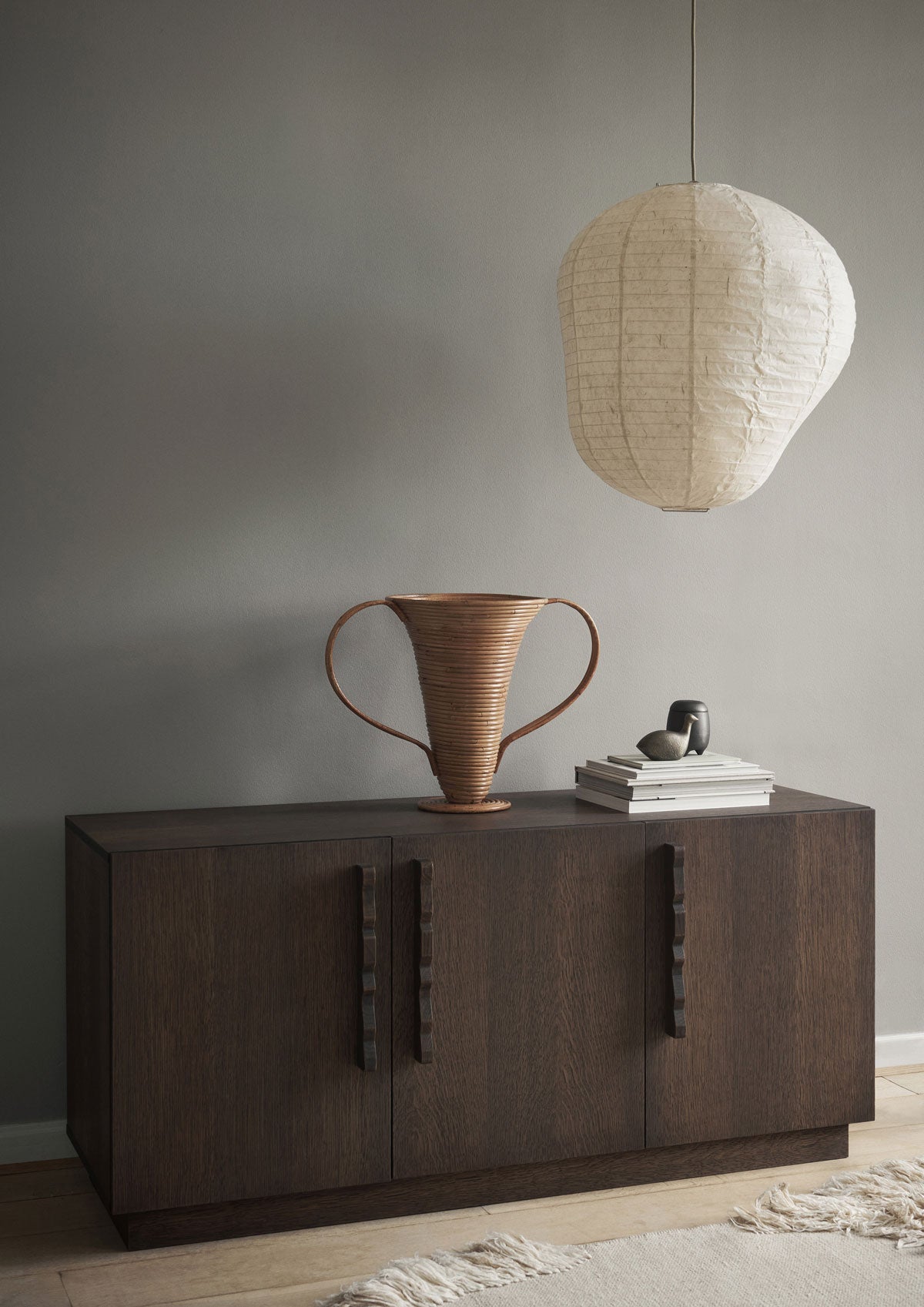 Kurbis Lampskärm i färgen Natural ovanför ett sideboard i mörkt trä