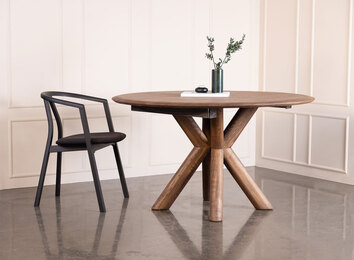 Matbordet Muhle i massiv brunoljad ask med vackra dekorationer och en svart stol