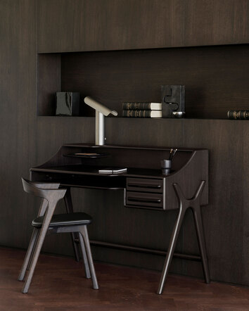 Flow Skrivbord i mahogny i färgen Rose Brown i ett rum klätt i mörkt trä