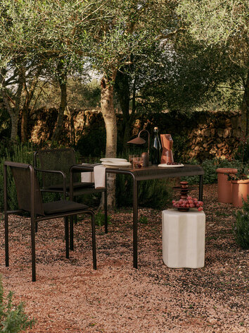 Dapple Stol, Dapple Karmstol och Dapple Bord 80x80 i färgen Dark Chocolate på uteplats i solnedgången