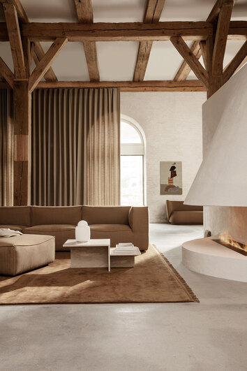 Distinct soffbord i travertin som del av soffgrupp i stort vardagsrum