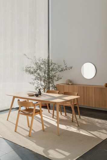 Tre stycken Flip Stol i naturlackad ek runt ett rektangulärt matbord i matplats med beige matta