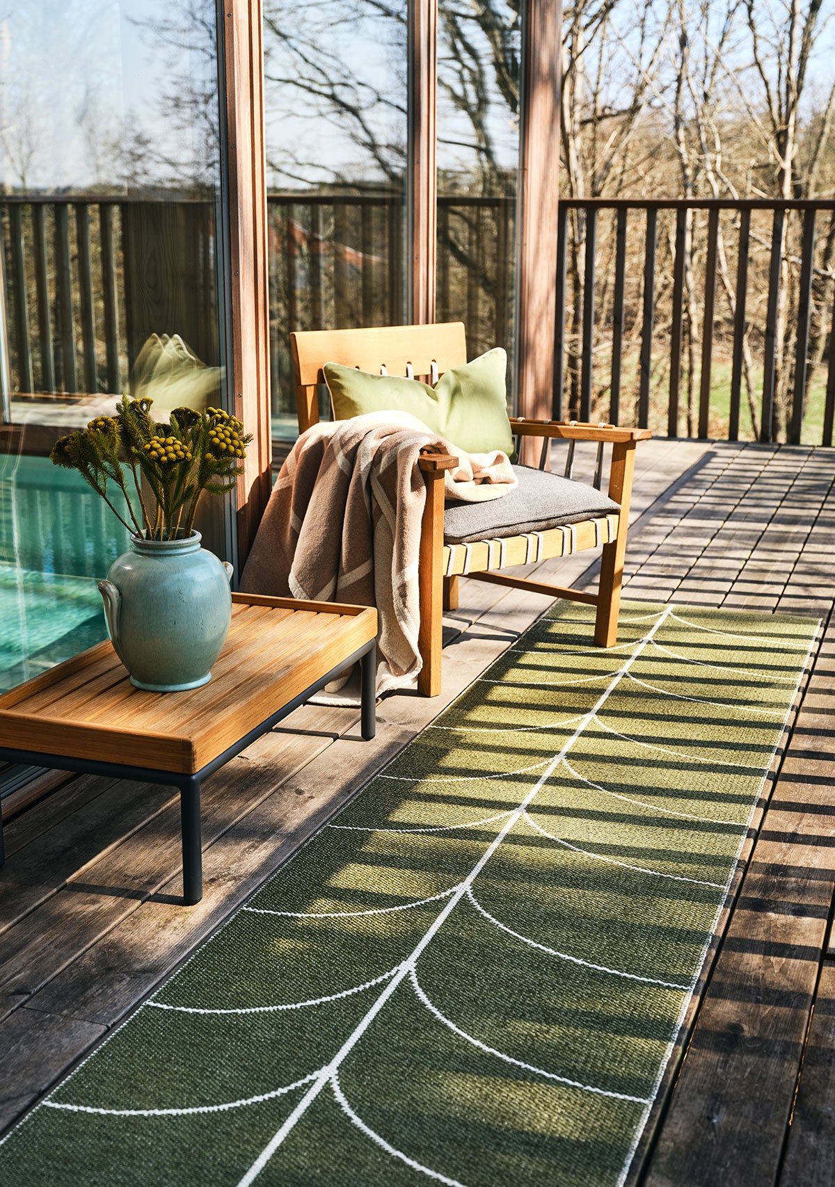 Framsida på Leif Gångmatta i färgen Pine på balkong i höstlandskap