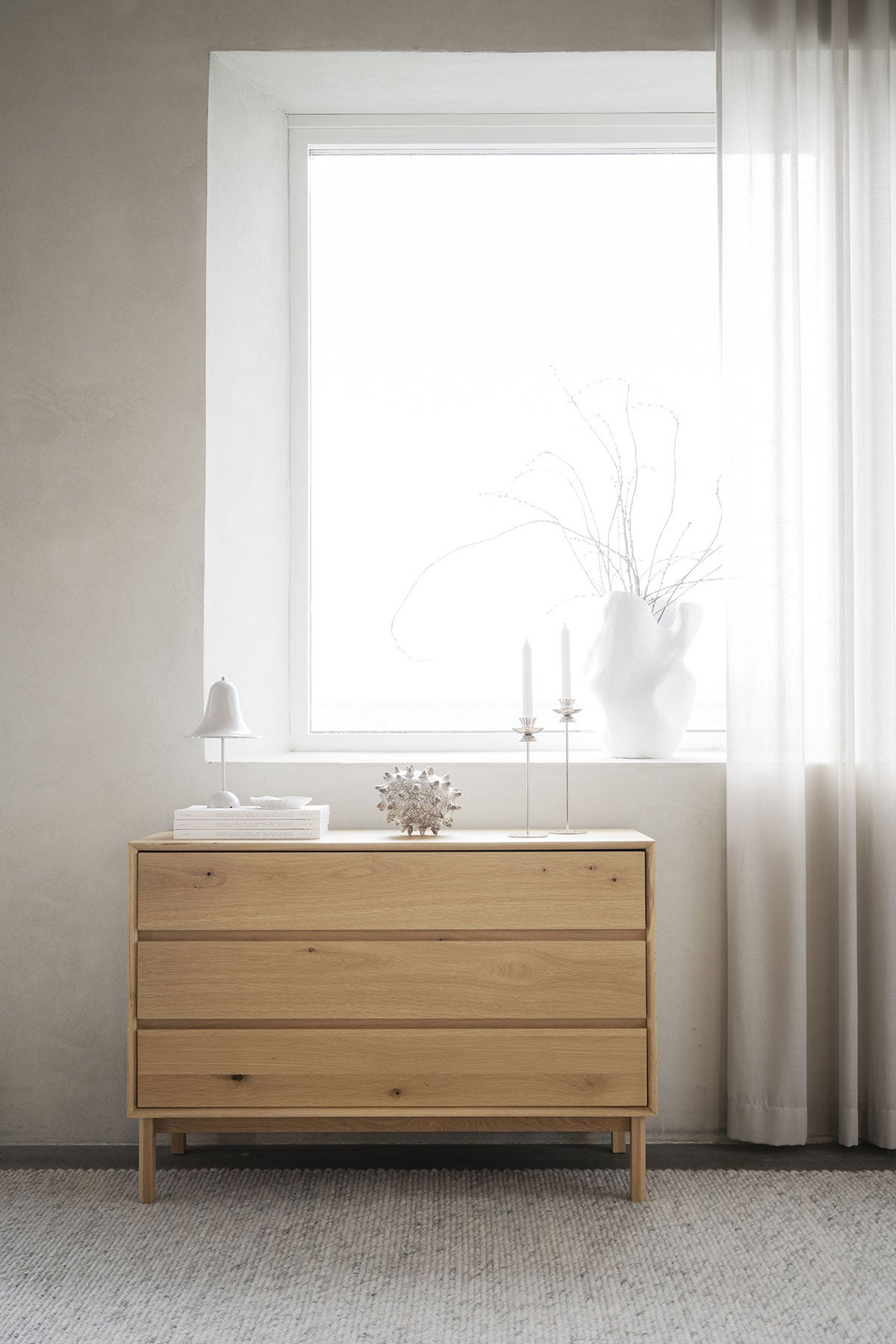 Mackay byrå i oljad ek ståendes framför ett ljust fönster 