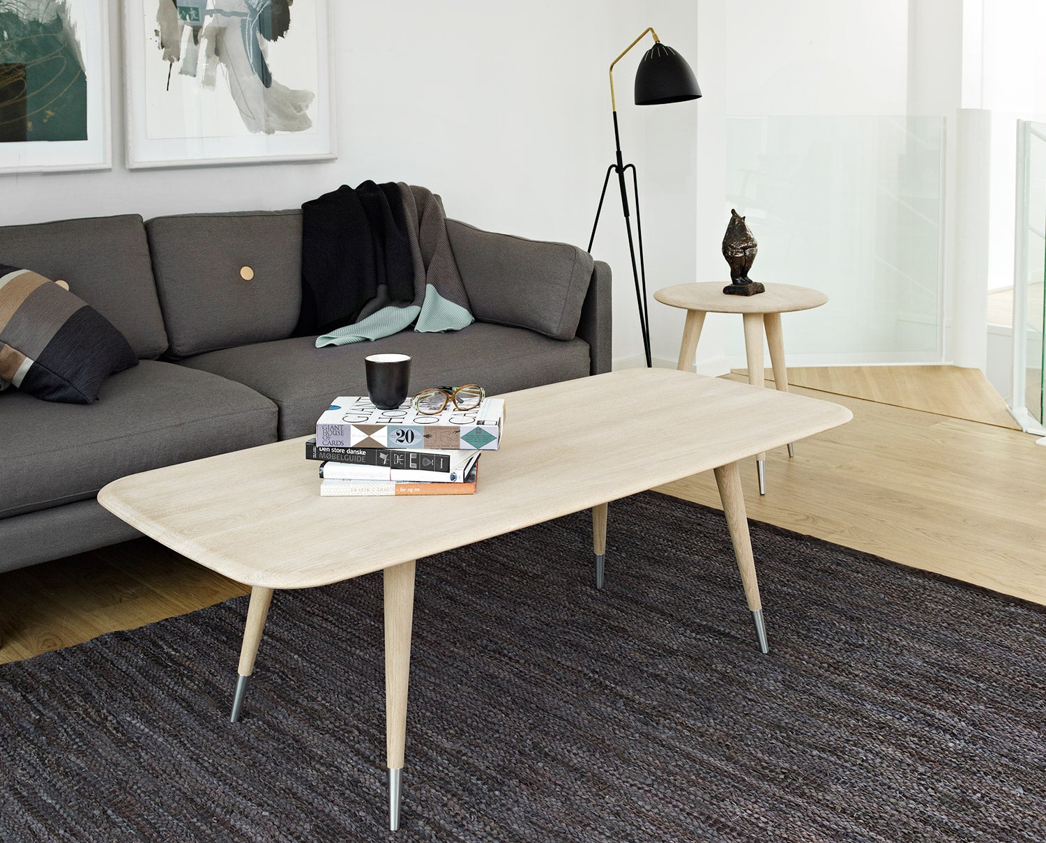 Point Soffbord AK 2530 på melerad matta framför en grå soffa med mörka textilier