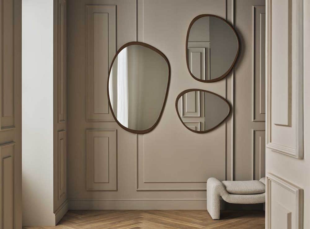 Bolia-Elope-Mirror-Collection-Dark-Oiled-Oak-Lifestyle.jpg Elope Spegel i olika storlekar i mörkoljad ek som hänger på en beige vägg.