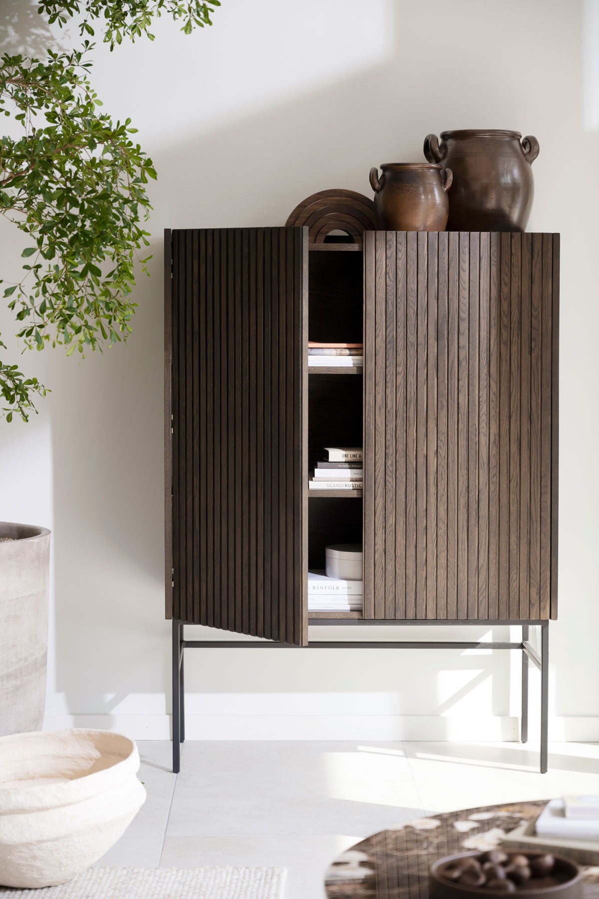 Halifax Skåp i brunlackad ek fyllt med böcker och tidningar