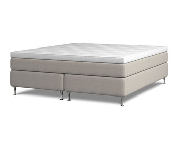 Kontinentalsängen Harmoni.  Bilden visar Harmoni med en bredd av 160 centimeter. Sängen är klädd i beige tyg. Benen är av förkromat stål. 