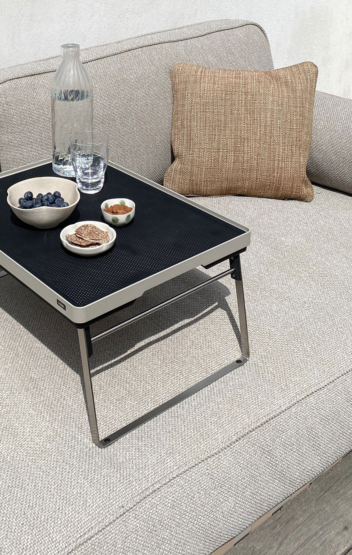 Vipp 272 Open-Air Bricka uppdukad med snacks på soffa utomhus
