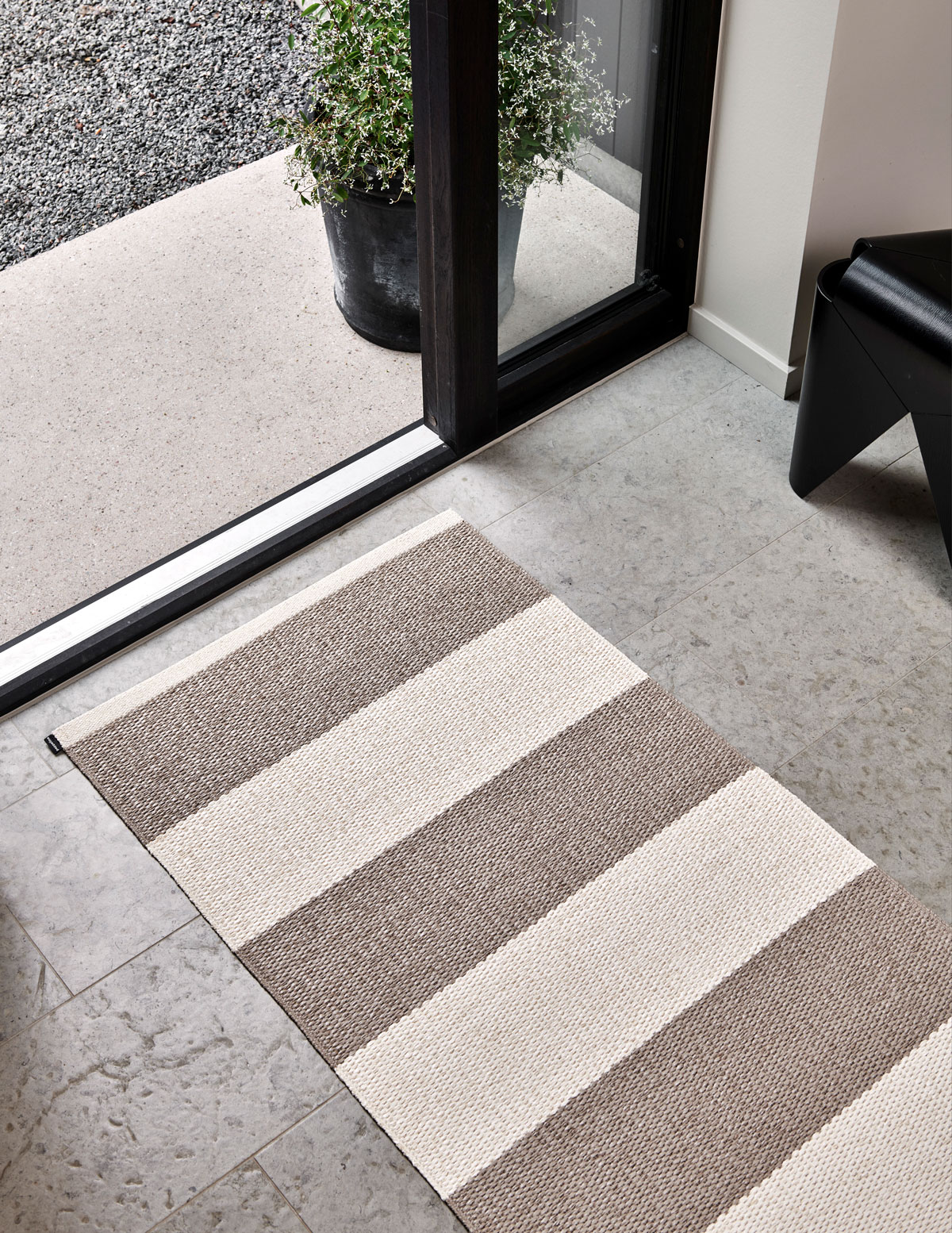 Bob Gångmatta i färgen Mud / Vanilla framför dörr