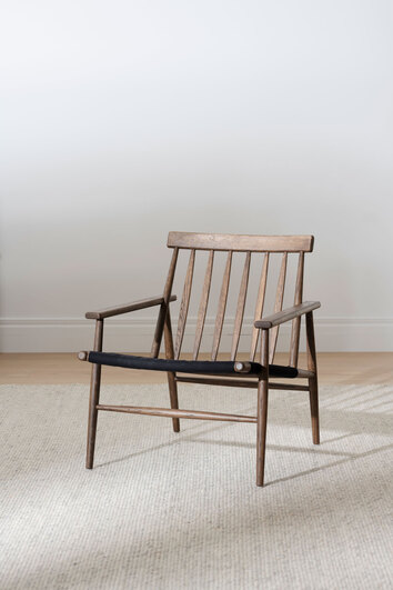 Canwood Loungestol Brunoljad Ek på beige ullmatta