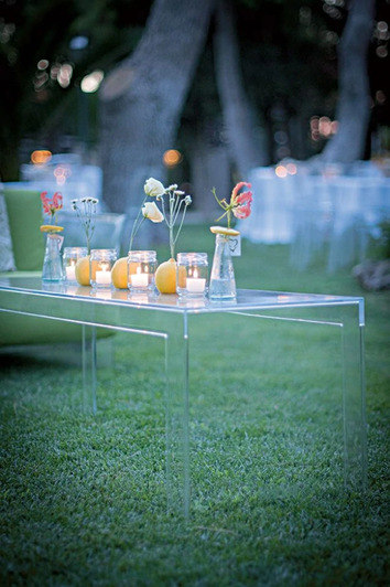 Invisible Soffbord Crystal dekorerat med tända ljus, citroner och vaser med blommor